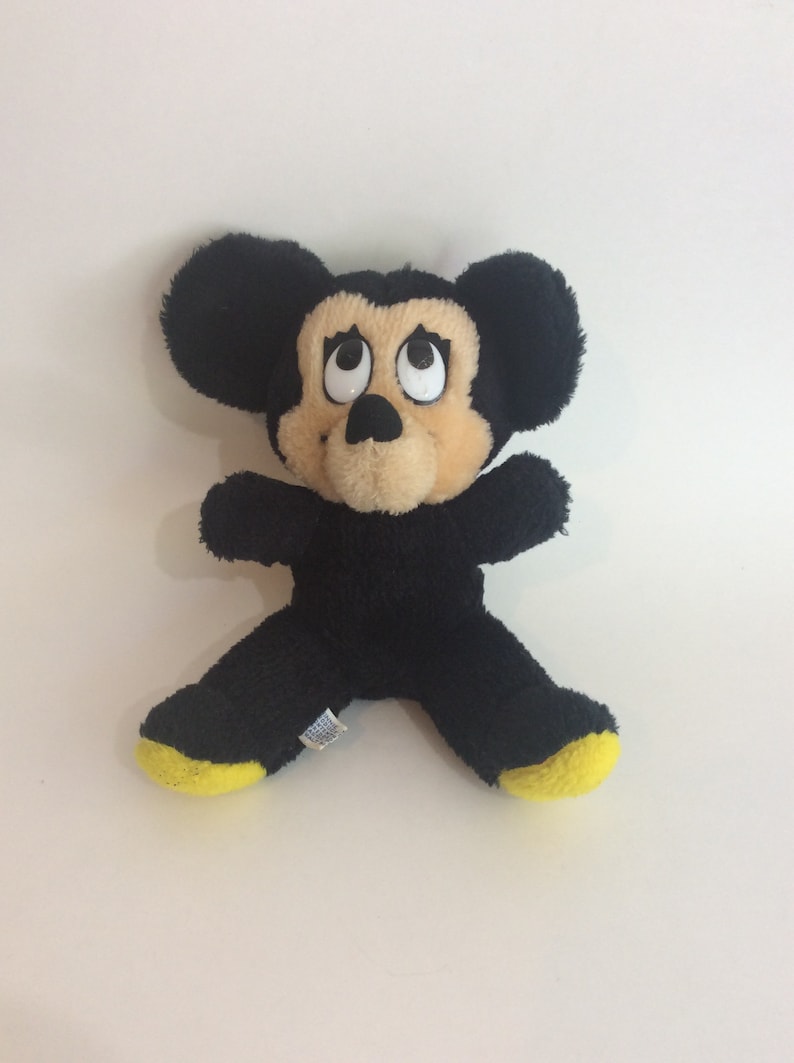 Puede incluir: Juguete de peluche Mickey Mouse negro y amarillo con ojos grandes.