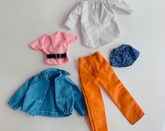 May include: A set of doll clothes including a white button-up shirt, a pink short-sleeved shirt, a blue denim jacket, orange pants, and a blue and white patterned skirt.