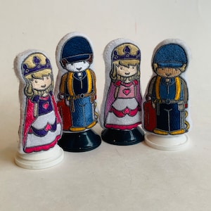 May include: Four finger puppets, two princesses and two firefighters, with embroidered details. The princesses wear pink and purple dresses with crowns and the firefighters wear blue uniforms with yellow accents.