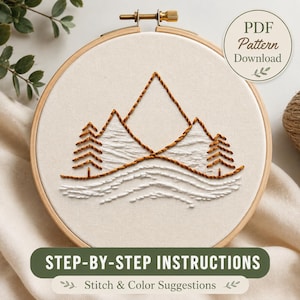 May include: An embroidery hoop containing white fabric with a stitched mountain landscape. The design features brown thread outlines of mountains and pine trees, with white satin stitch fill for snow. Text reads PDF Pattern Download and Step-by-Step Instructions.