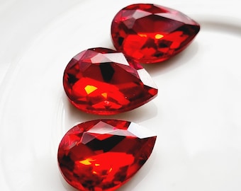 May include: Three red teardrop-shaped crystal rhinestones.
