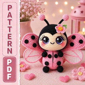 May include: A handmade crocheted ladybug toy, predominantly pink and black, with large, detailed eyes and a flower detail. The wings have black spots. The image includes the text "PATTERN PDF" in pink, suggesting a pattern is available.