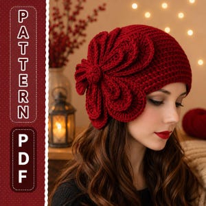 Puede incluir: Primer plano de un gorro rojo tejido a ganchillo con un gran diseño floral en el lateral. El gorro está hecho de un hilo texturizado y lo lleva una persona con el pelo largo y castaño. La imagen también incluye el texto "PATTERN PDF".