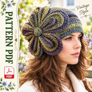 Può includere: Un cappello all'uncinetto con un grande fiore a più strati in tonalità variegate di viola, verde e blu. Il testo sul lato recita PATTERN PDF e Vintage Style. Il cappello presenta un motivo a maglia a coste testurizzato su tutto il design.