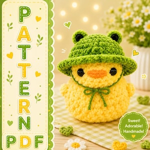 May include: A yellow crocheted duckling wearing a green frog-shaped hat with black eyes and an orange beak. The image includes a vertical banner with the text PATTERN PDF and a circular badge with the text Sweet! Adorable! Handmade!