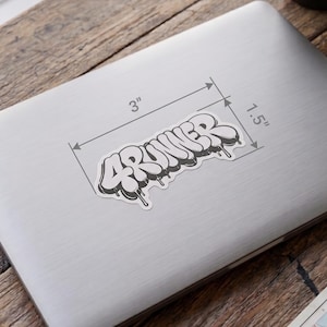 May include: A white vinyl sticker featuring the text 4RUNNER in a black and white graffiti-style font with a dripping effect. The sticker is displayed on a silver laptop lid with measurement lines indicating a width of 3 inches and a height of 1.5 inches.
