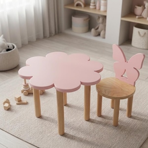 Könnte beinhalten: Ein hellrosa blumenförmiger Tisch mit vier hellen Holzbeinen und ein passender hellrosa Stuhl mit einer schmetterlingsförmigen Rückenlehne und einer runden Sitzfläche aus hellem Holz, konzipiert für Kinder in einem Spielbereich.