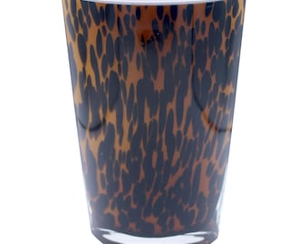 Op de afbeelding: Een glazen vaas met een bruine en zwarte luipaardprint.