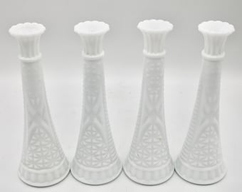 Puede incluir: Juego de cuatro jarrones de leche de vidrio blanco con un diseño texturizado. Los jarrones son altos y delgados con una parte superior acampanada.