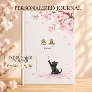 May include: A white hardback journal featuring a watercolour illustration of pink cherry blossoms at the top and a black kitten reaching for a butterfly at the bottom. The text reads PERSONALIZED JOURNAL, the kanji 惠真, and the name EMMA.