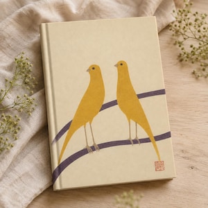 May include: A hardcover notebook with a cream-colored cover featuring two yellow birds perched on two dark purple curved lines. A small red square stamp with Asian characters is located in the bottom right corner of the front cover.