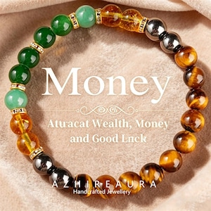 May include: A beaded bracelet with green, yellow, and brown gemstones. The bracelet includes the word "Money" and the text "Attract Wealth, Money and Good Luck". The bracelet is handcrafted.