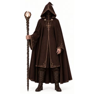 May include: A dark brown hooded cloak featuring intricate gold embroidery along the edges and chest, paired with a long, twisted dark staff topped with a glowing orb. The ensemble includes dark trousers and tall, textured brown leather boots.