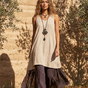 Ta przewiewna, lniana bluzka w stylu boho, wiązana z przodu, ma zwiewny fason, który tworzy wyrazisty klimat boho.