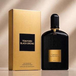 May include: A black perfume bottle and a gold box. The bottle has a black cap and a gold label that reads "TOM FORD BLACK ORCHID". The box is gold with the same text on a black square. The box also says "EAU DE PARFUM VAPORISATEUR SPRAY 3.4 FL.OZ./OZ.LIQ./100 ml".
