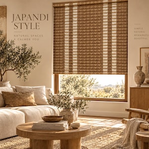 May include: A woven bamboo window shade with vertical white stripes covering a window. The shade features a natural brown texture and is installed in a room with a sofa, a round wooden coffee table, and a decorative ceramic vase.