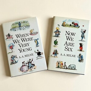 May include: Two hardcover books by A.A. Milne with light-coloured covers. The left book is titled When We Were Very Young and the right book is titled Now We Are Six. Both covers feature multiple small, colourful illustrations of characters and scenes.