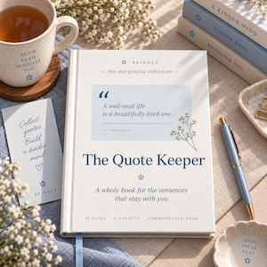 Puede incluir: Un libro de tapa dura blanco titulado The Quote Keeper con texto azul, una cita sobre una vida bien leída y una pequeña ilustración floral. El libro se acompaña de un marcapáginas, un bolígrafo azul, una taza y libros apilados.