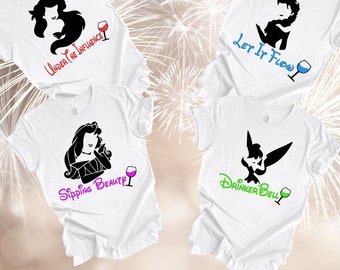 May include: Four white t-shirts with black silhouettes of Disney princesses and wine glasses. The shirts have the text "Under the Influence", "Sipping Beauty", "Let It Flow", and "Drinker Bell".