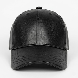 A black baseball cap with a textured, leather-like finish. The cap features a structured six-panel crown with a central button at the top and a curved brim with visible stitching detail along the edge of the visor and the crown panels.