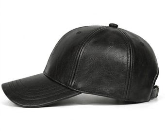 Peut inclure: Une casquette de baseball noire avec une finition texturée semblable à du cuir. La casquette présente une calotte structurée à six panneaux, une visière incurvée avec des coutures visibles et une sangle réglable à l'arrière. La matière a un motif.