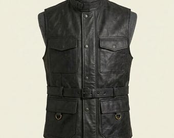 Peut inclure: Un gilet en cuir noir doté d'un col montant avec une sangle à boucle, d'une fermeture à boutons-pression sur le devant et de quatre grandes poches à rabat. La taille comprend une ceinture réglable à boucle et deux anneaux en D en métal.