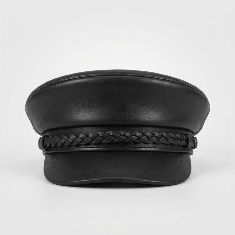 A black leather fiddler newsboy boy cap featuring a smooth rounded crown and a short, stiff brim. A decorative braided leather band wraps horizontally around the base of the crown, secured by small leather loops on each side of the hat.