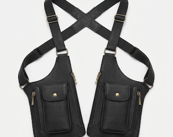 Peut inclure: Un sac holster d'épaule noir à double pochette avec des sangles élastiques réglables croisées dans le dos. Chaque pochette comprend un compartiment zippé vertical et une petite poche avant avec fermeture à bouton-pression, ornée de détails métalliques.