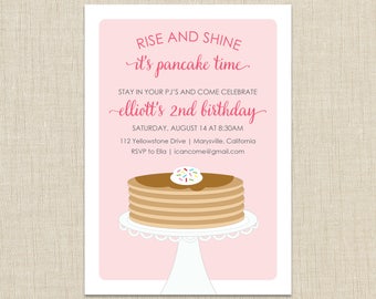 May include: Pink invitation with a stack of pancakes with syrup and sprinkles on top. The text reads "Rise and Shine it's pancake time. Stay in your PJ's and come celebrate elliott's 2nd birthday. Saturday, August 14 at 8:30 AM. 112 Yellowstone Drive | Marysville, California. RSVP to Ella | icancome@gmail.com"