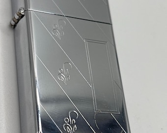 The Zippo Slim High Polish Chrome lighter with a diagonal retro design