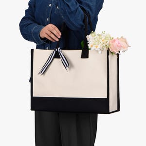 a woman holding a white and black bag