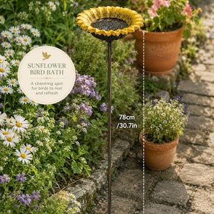 Puede incluir: Un ba&ntilde;o para p&aacute;jaros con forma de girasol, con un borde de p&eacute;talos amarillos y un centro negro, montado sobre una fina estaca de metal. El cuenco mide 13,5 cm de di&aacute;metro y la altura total es de 78 cm. El texto en la imagen dice: SUNFLOWER BIRD BATH.