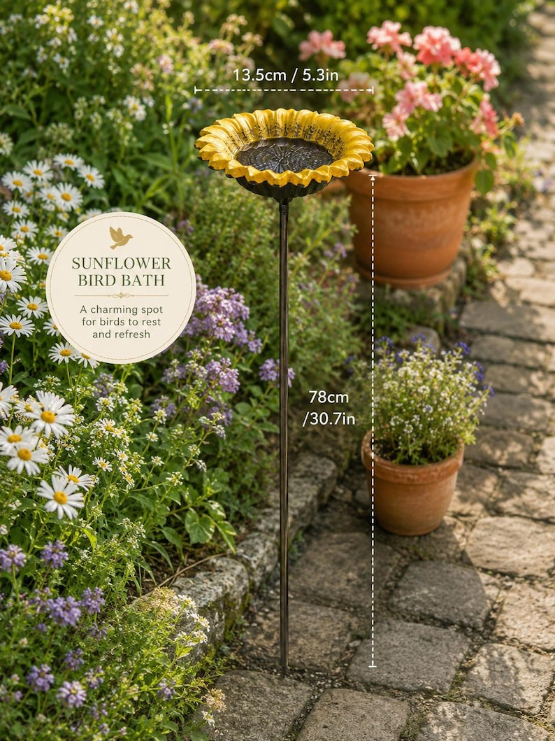 Puede incluir: Un ba&ntilde;o para p&aacute;jaros con forma de girasol, con un borde de p&eacute;talos amarillos y un centro negro, montado sobre una fina estaca de metal. El cuenco mide 13,5 cm de di&aacute;metro y la altura total es de 78 cm. El texto en la imagen dice: SUNFLOWER BIRD BATH.