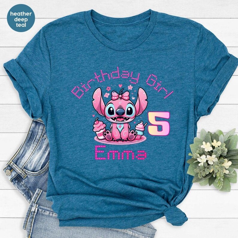May include: A teal t-shirt featuring a pink cartoon character with the text "Birthday Girl" and the number "5". The character is holding cupcakes and the name "Emma" is displayed below.