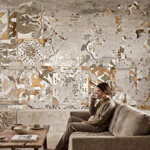 May include: A wall mural featuring a distressed, weathered pattern of overlapping tiles in shades of muted gold, gray, and white. The design displays intricate floral and geometric motifs with a faded, aged aesthetic that mimics peeling plaster.