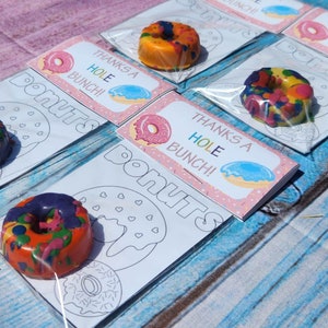 May include: A set of five donut-shaped crayon favors with a coloring page. Each favor includes a colorful crayon donut and a card that says "Thanks a Hole Bunch!"