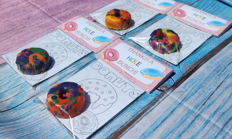 May include: A set of five donut-shaped crayon favors with a coloring page. Each favor includes a colorful crayon donut and a card that says "Thanks a Hole Bunch!"