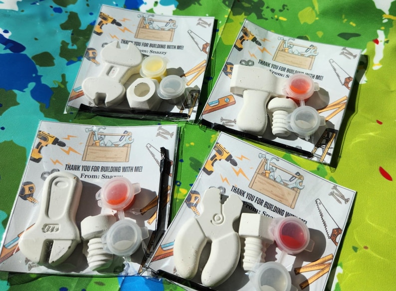 May include: Four favour bags with a white toy wrench and screw, a small container of paint, and a thank you note that reads "Thank you for building with me! From: Snazzy".