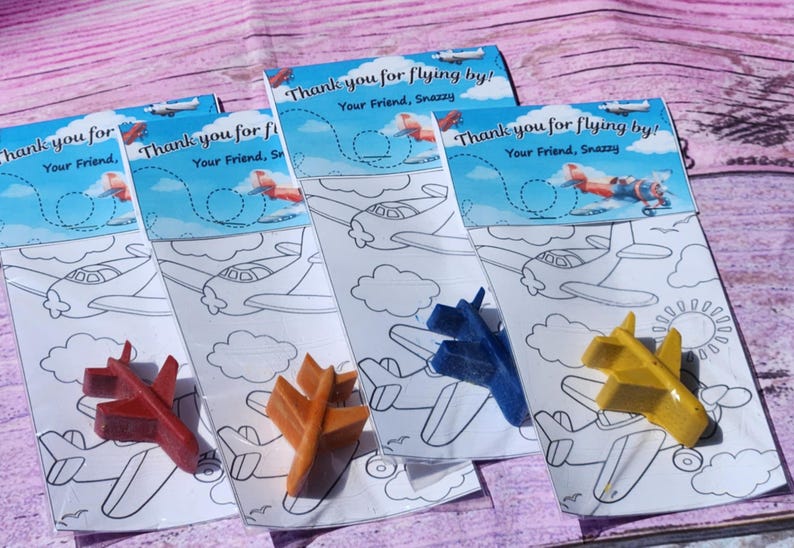 Puede incluir: Cuatro p&aacute;ginas para colorear con aviones y un cray&oacute;n de avi&oacute;n azul, amarillo, rojo y naranja. Las p&aacute;ginas para colorear tienen el texto "&iexcl;Gracias por volar! Tu amigo, Snazzy" en la parte superior.