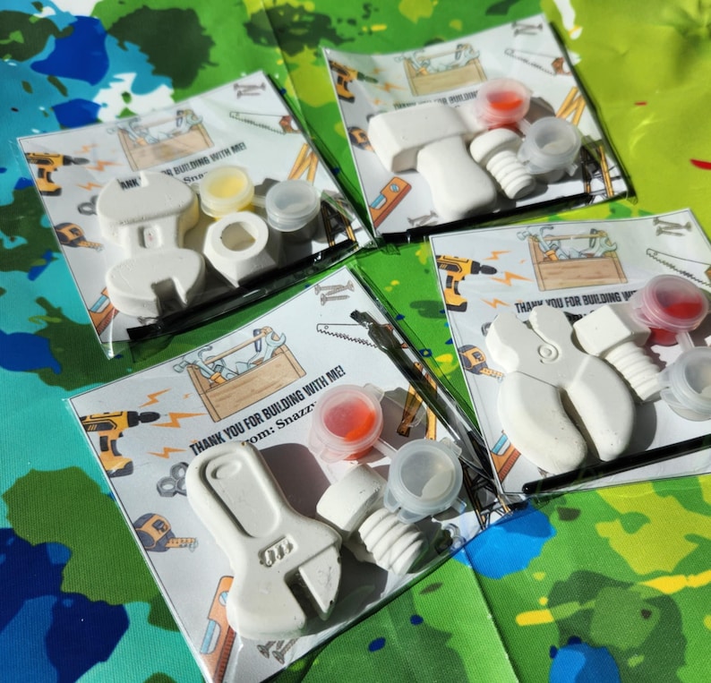 May include: Four favour bags with a white wrench, hammer, and screwdriver, paint, and a thank you note that says "Thank you for building with me! from: Snazz".
