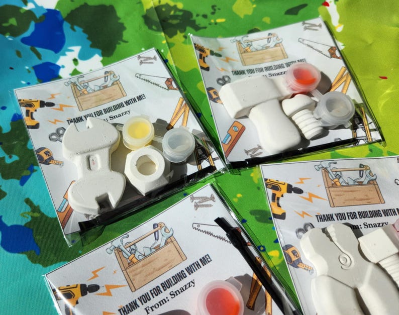 May include: Thank you for building with me! Party favour bags with a white plastic tool, paint, and a thank you note. The note says "Thank you for building with me! From: Snazzy".