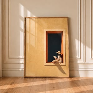 Può includere: Una stampa artistica da parete rettangolare incorniciata con uno sfondo giallo senape testurizzato e un ritaglio rettangolare centrale. All'interno, una persona con un cappello di paglia e abiti chiari legge un libro contro un cielo blu scuro.