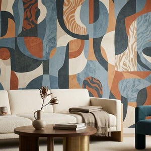 May include: A modern living room featuring a cream-colored sofa with wooden accents, a round coffee table, and a teal armchair. The focal point is a large wall mural with an abstract design in shades of blue, brown, and beige.
