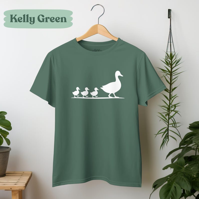 Minimalist motherhood animal t-shirt featuring mama duck leading baby ducklings illustration.