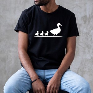 Nature-inspired duckling graphic t-shirt featuring clean simple silhouette artwork and relaxed fit.