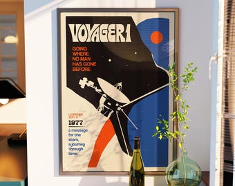 Op de afbeelding: Een ingelijste poster getiteld VOYAGER 1 met een grafische illustratie van de ruimtesonde, inclusief de tekst GOING WHERE NO MAN HAS GONE BEFORE, LAUNCHED SEPT 5 1977, en a message for the stars, a journey through time, in zwart, blauw en oranje.