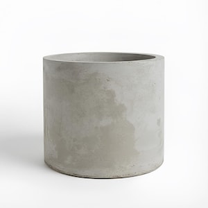 May include: A cylindrical planter made of light grey concrete with a smooth, matte finish. The exterior surface displays subtle variations in tone and texture, characteristic of natural cement, with a wide, open top and a flat, circular base.