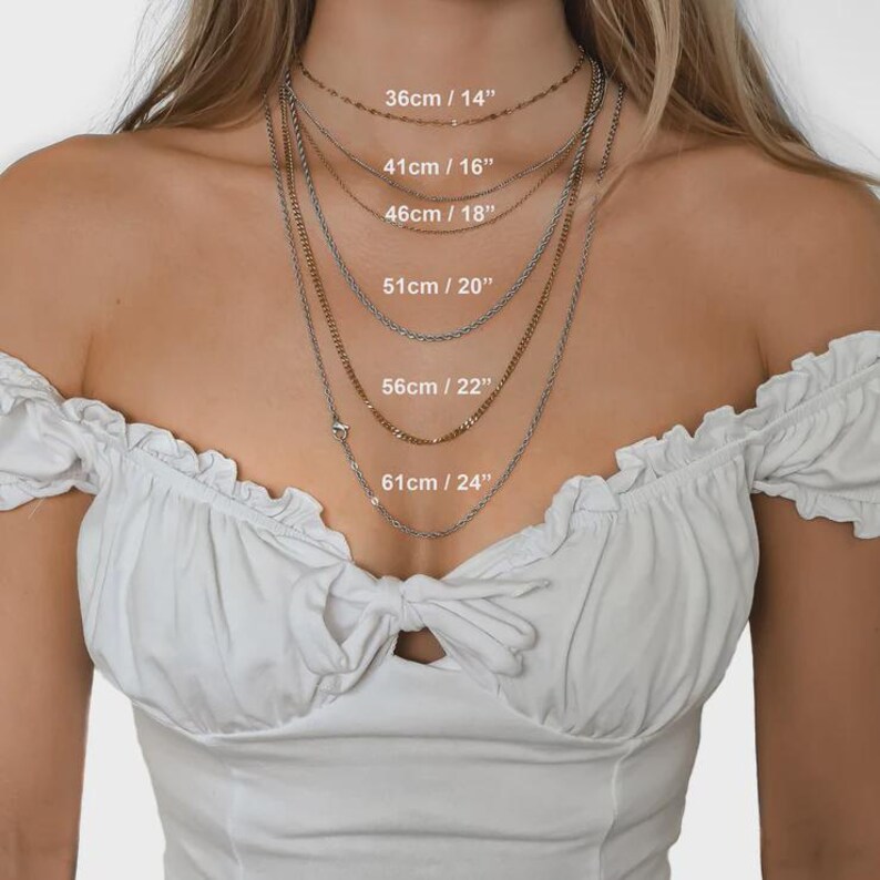 May include: A collection of layered necklaces in gold and silver. The image shows the necklaces with their lengths indicated in both centimetres and inches: 36cm/14", 41cm/16", 46cm/18", 51cm/20", 56cm/22", and 61cm/24".