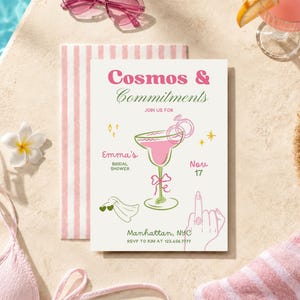 May include: A rectangular bridal shower invitation card with the text Cosmos & Commitments, featuring a pink cocktail illustration, a ring, a veil, and a hand with a ring. The card includes details for Emma's bridal shower on Nov 17 in Manhattan, NYC.