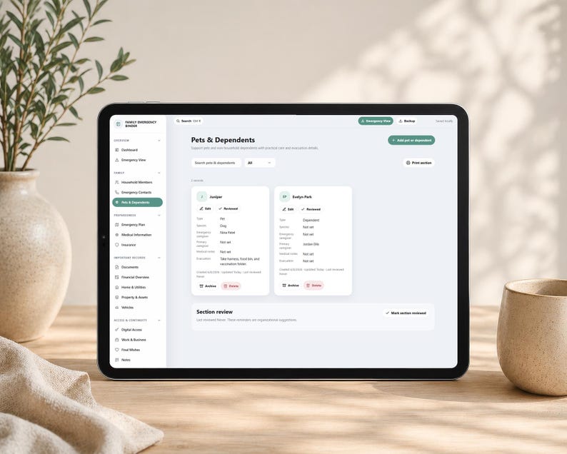 May include: A tablet displaying a digital interface titled Pets & Dependents, featuring a sidebar with navigation categories like Dashboard, Emergency View, and Documents. The screen shows two profile cards for Juniper and Evelyn Park.